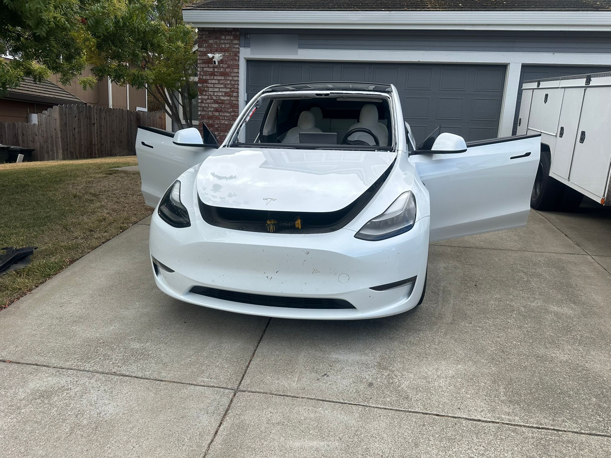 White Tesla Model Y in driveway during mobile windshield replacement service by Walnut Creek Auto Glass